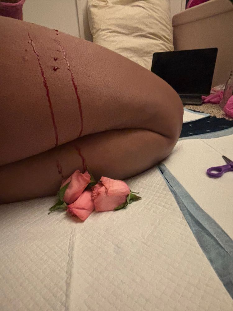 Blood dripping down Sonya’s thighs onto three roses