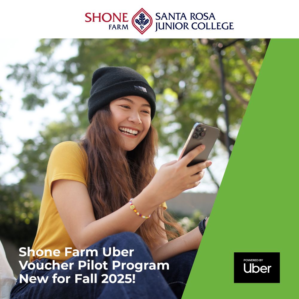 A female student is looking at her phone and smiling. 