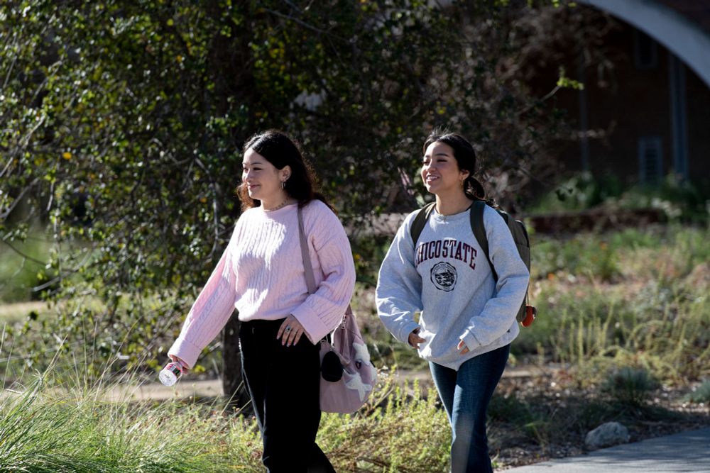 Two female students are walking on the SRJC campus quad. 