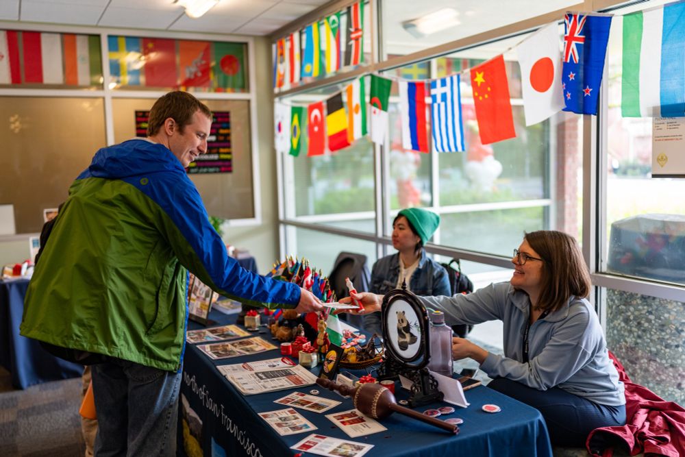 A man takes an informational brochure from a college employee tabling during the Financial Aid Fun Fair at Santa Rosa Junior College. 