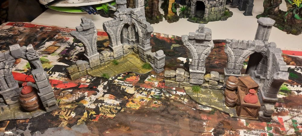 3d printed models of ruined castle walls, painted grey with a yellow paint wash covering the floors
