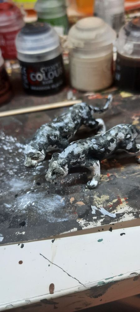 Plastic toy lions, painted like grayish leopards