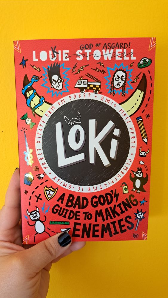 I'm holding a copy of Loki: A Bad God's Guide to Making Enemies by Louie Stowell. It's bright red and has Georgina and Loki staring daggers at each other, as well as all sorts of relevant doodles to the book plot.
