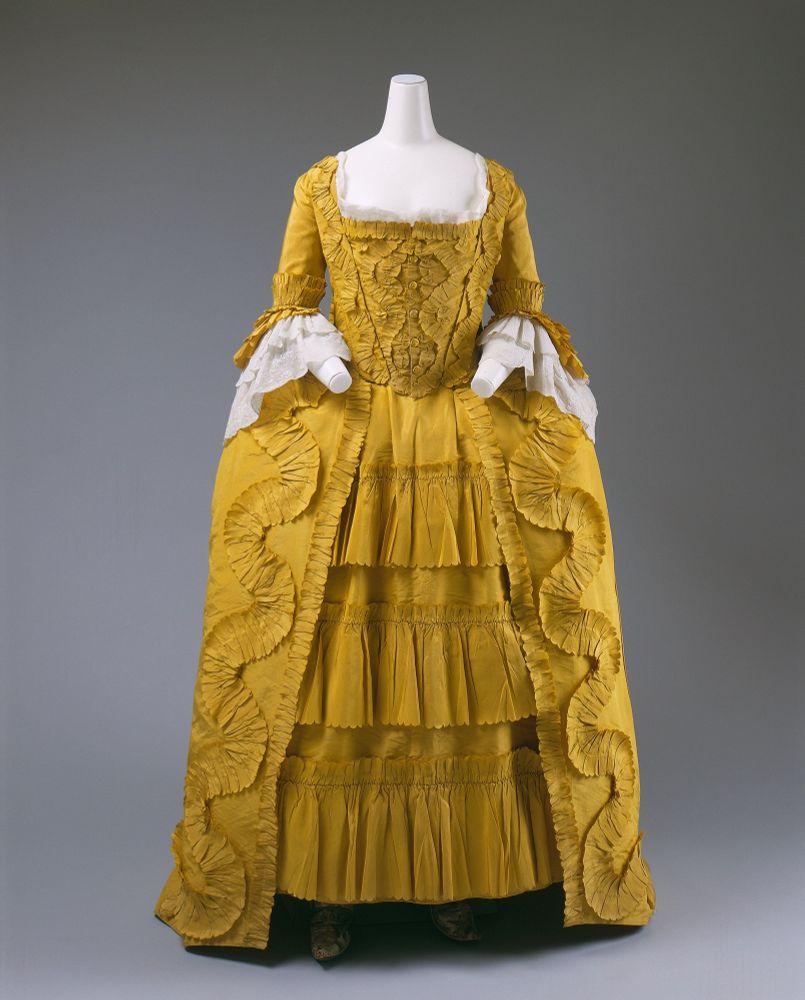 Image 2. Front view of the dress from image 1. The width of the panniers extending the hipline of the dress are evidence here. 