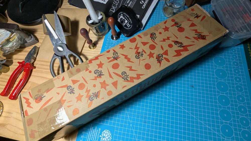 photo couleur d'un carton long posé sur un plan de travail en bazar.