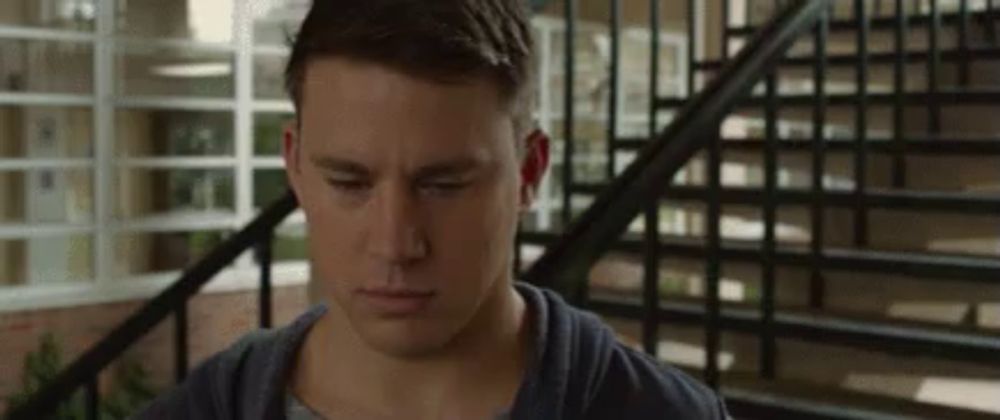 a young man is standing in front of a set of stairs .