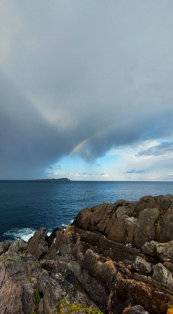 Cielo de tormenta con un arcoíris tímido, sobre el mar...