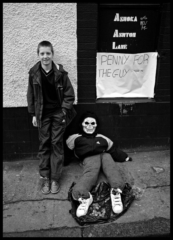 Boy with Guy Fawkes effigy and sign reading “Penny for the Guy”