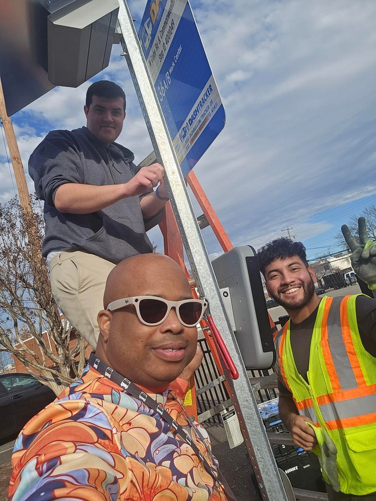 A group of DASH employees installing new bus stop information screens