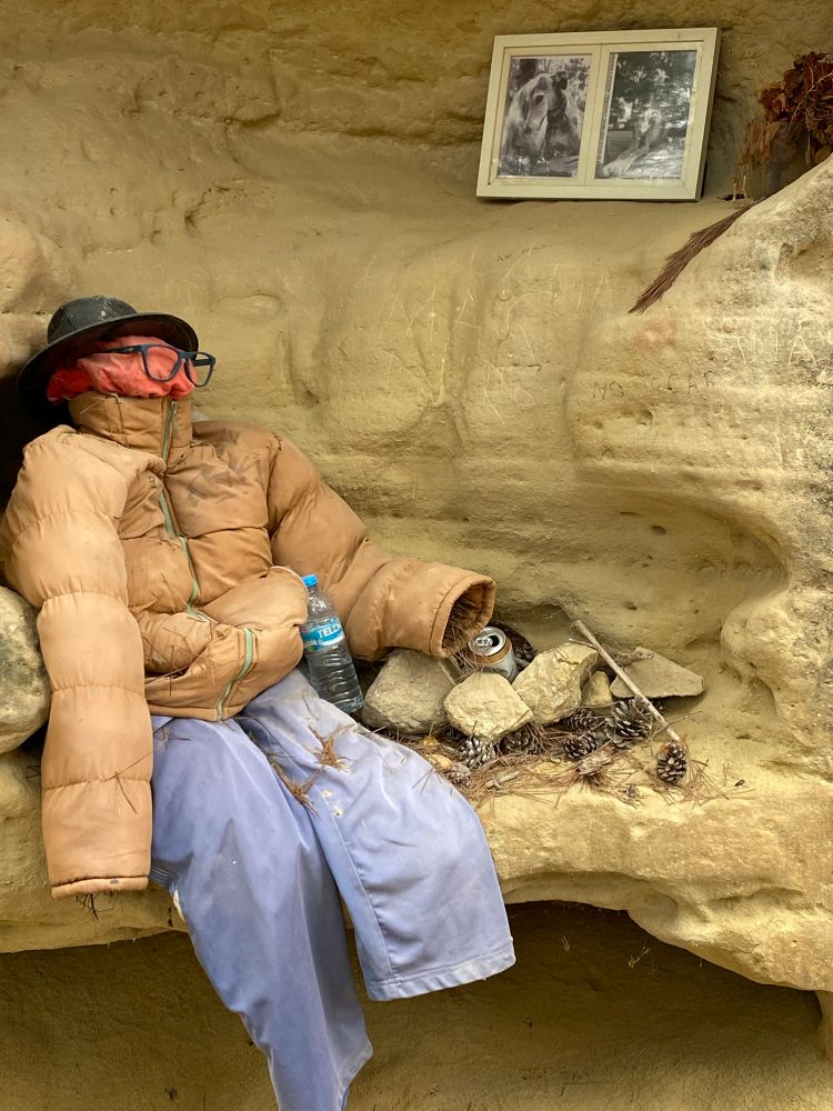 Scarecrow guarding little personal dog shrine