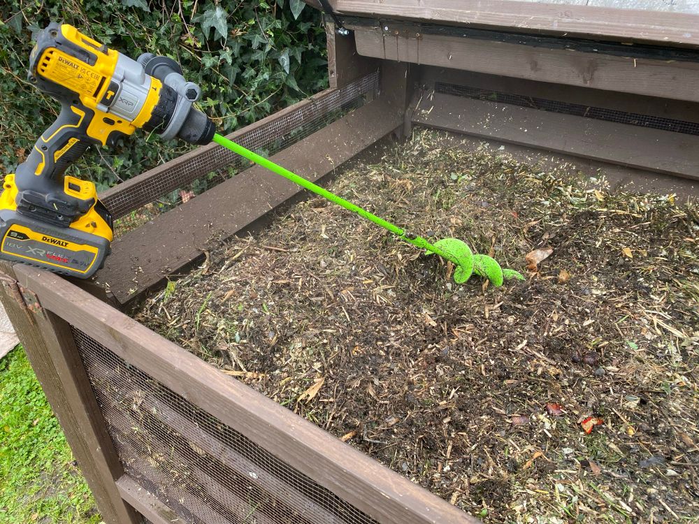 Compost being stirred with drill and compost corkscrew