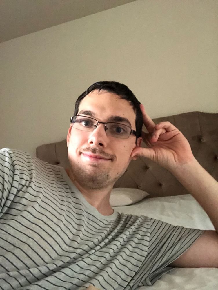 A dude with a mustache, glasses and a striped shirt