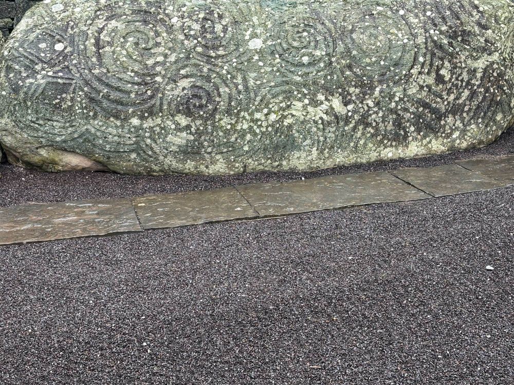 A close up of the same large gray stone from the entrance carved with megalithic art