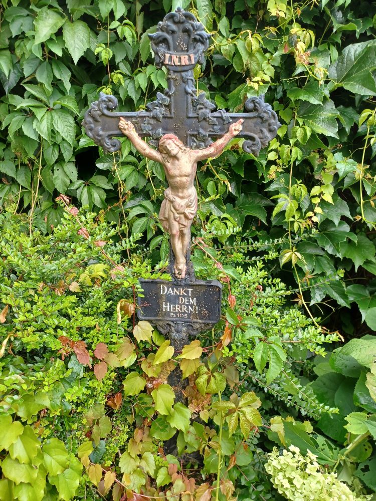 Altes schmiedeidernes Kruzifix, statt eines Namens steht da: Dankt dem Herrn!