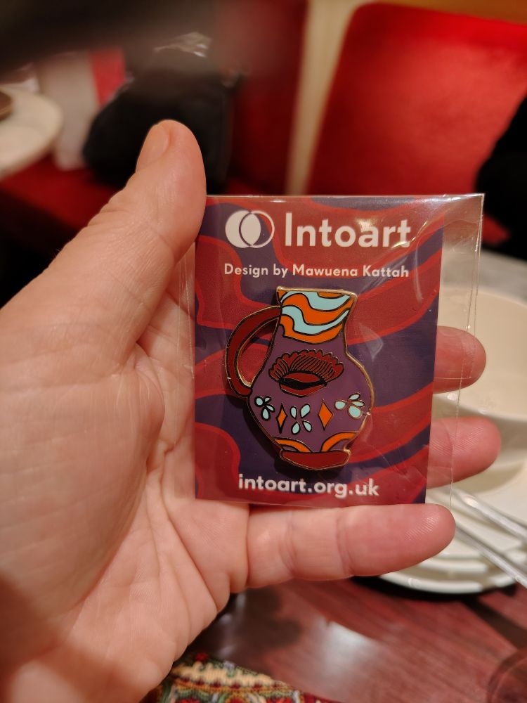 Emaljpin som föreställer en vas av konstnären Mawuena Kattah