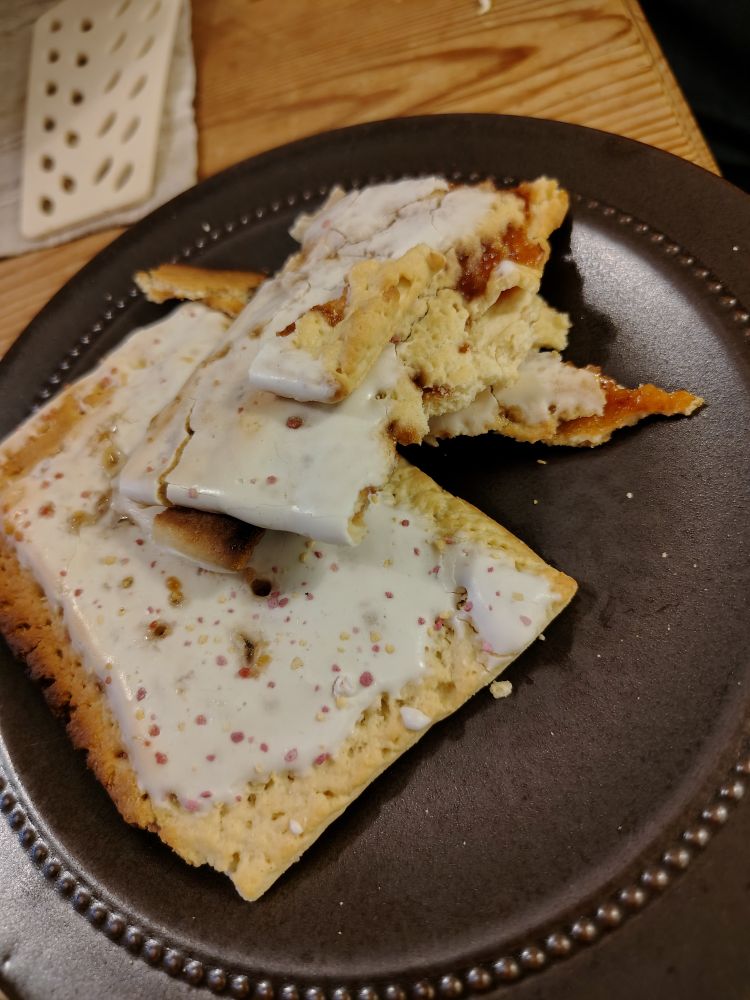 Två poptarts som varit i brödrosten, en har gått sönder så man ser lite fruktfyllning.