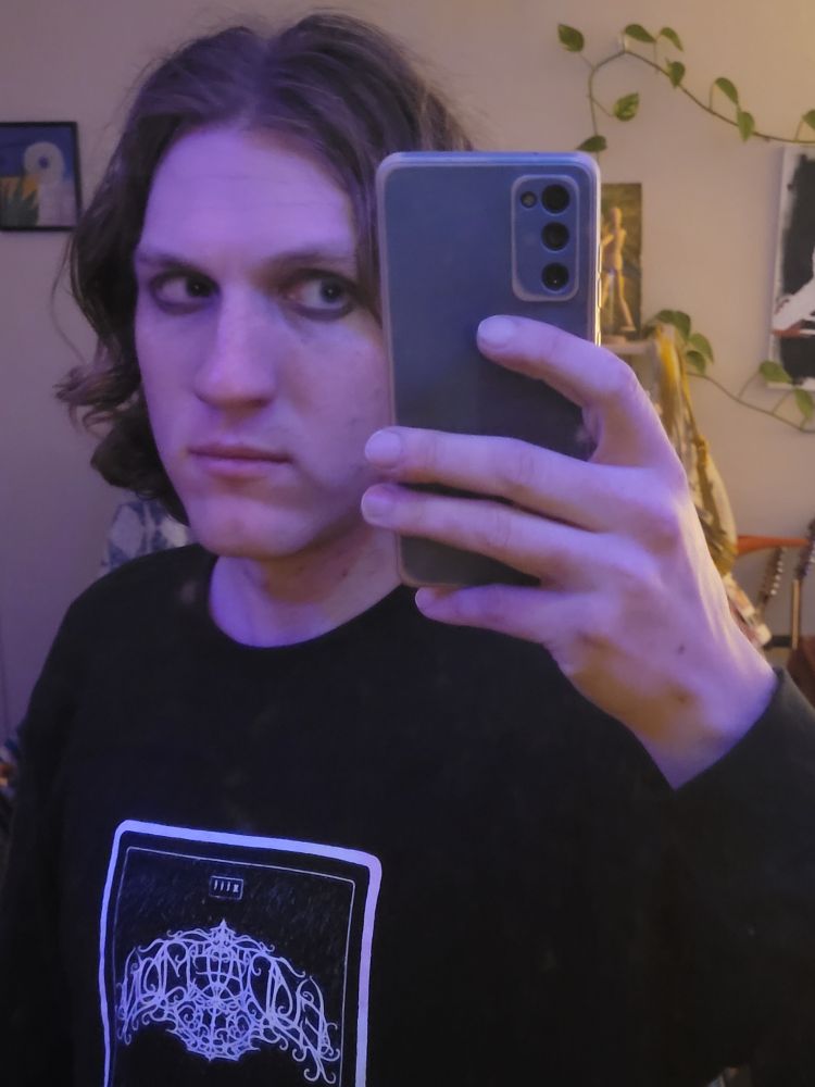 Selfie of me after show with black Eudaemon shirt and wavy blond hair