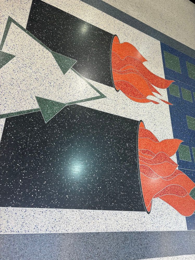 Floor tiles depicting a pair of burning barrels, likely trash cans given what appears to be a recycling symbol of green arrows overlaid between them.