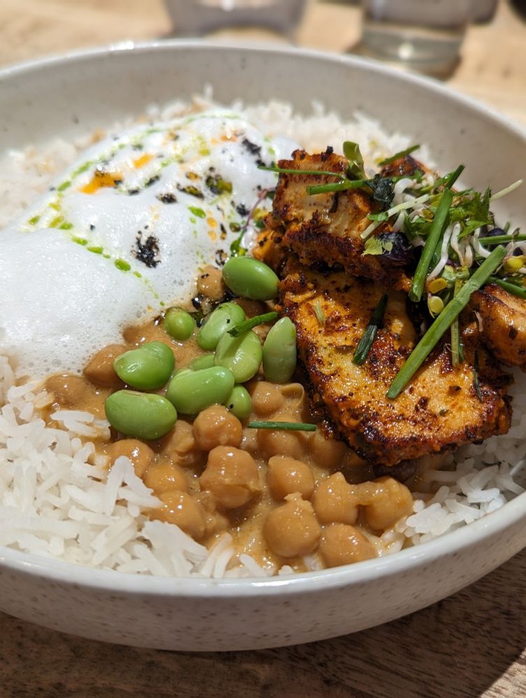 Schüssel mit Reis, Kichererbsen Curry, Edamame, Hähnchen und Kräuter