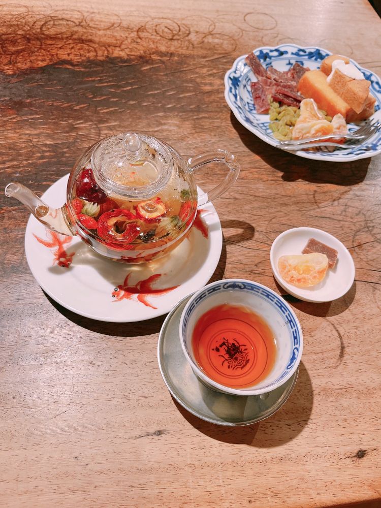 ガラスの急須に八宝茶が入っており、隣にはお茶請けのお菓子が置いてある。