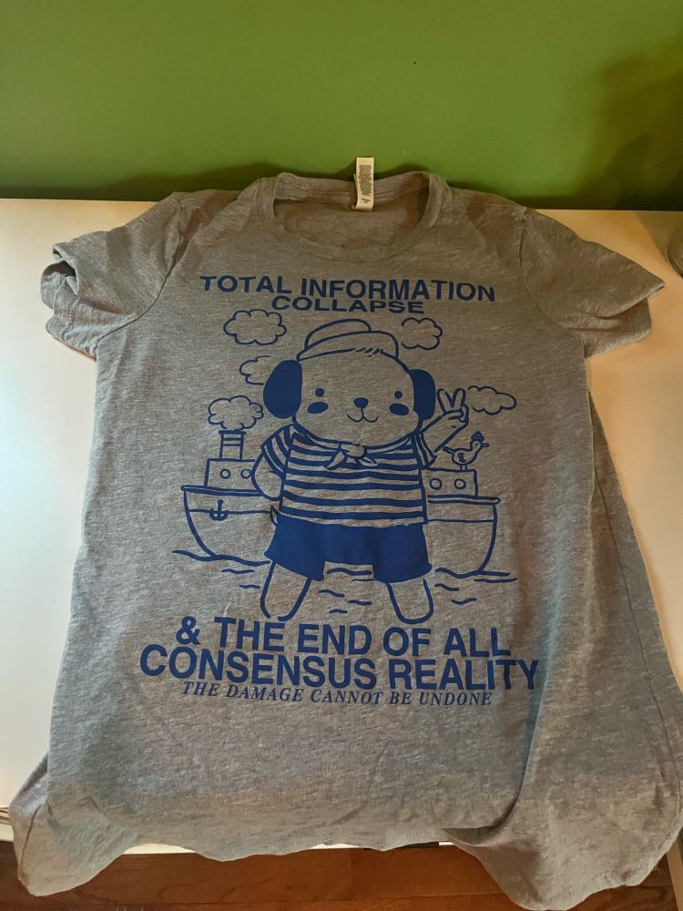 T-shirt with a cartoon sailor dog that says “total information collapse and the end of all consensus reality, the damage cannot be undone”