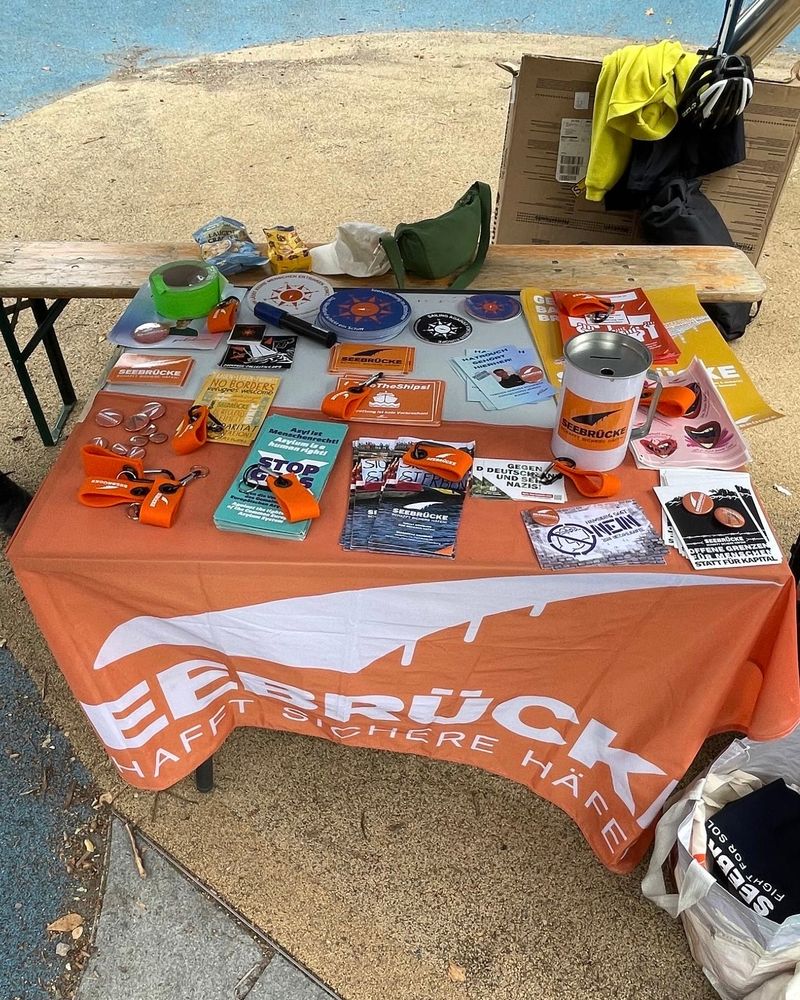 Foto eines Infostands mit Flyern, Stickern und Schlüsselbändern.