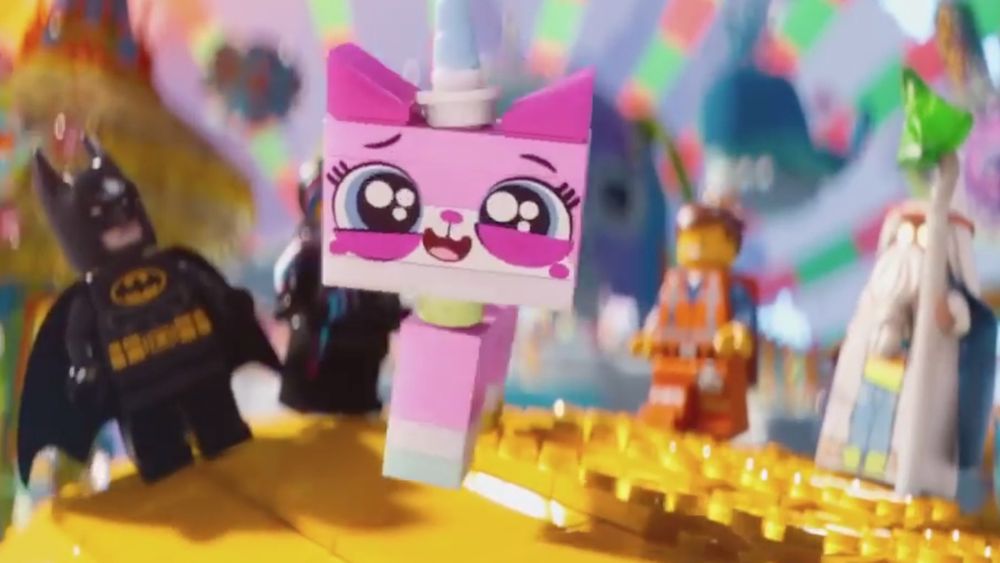 A pink and white Lego cat with a blue unicorn horn