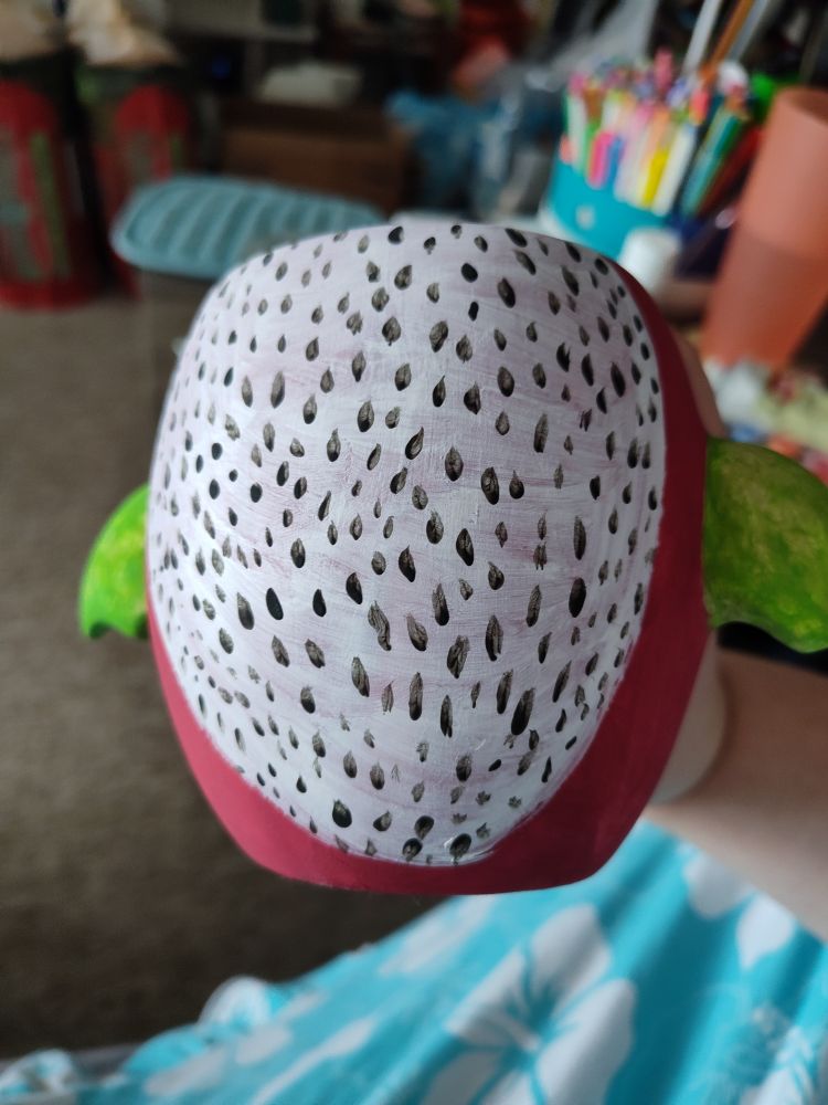 The back of the dragon fruit plant pot looks like the inside of a dragon fruit: white with black seeds all over