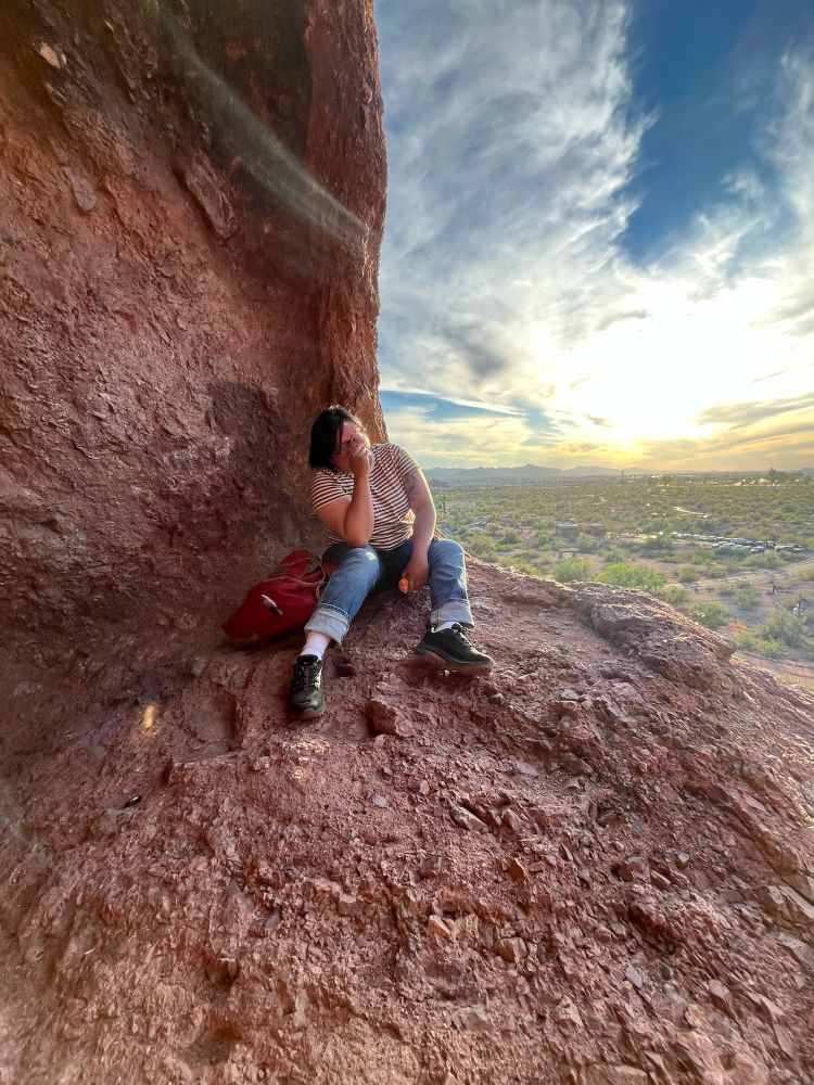 Me laughing, probably embarrassed LOL, in a corner of Hole in the Rock with a sunset view behind me. 