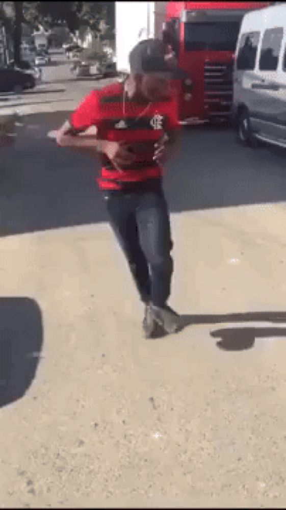 a man in a flamengo shirt is dancing in front of a truck