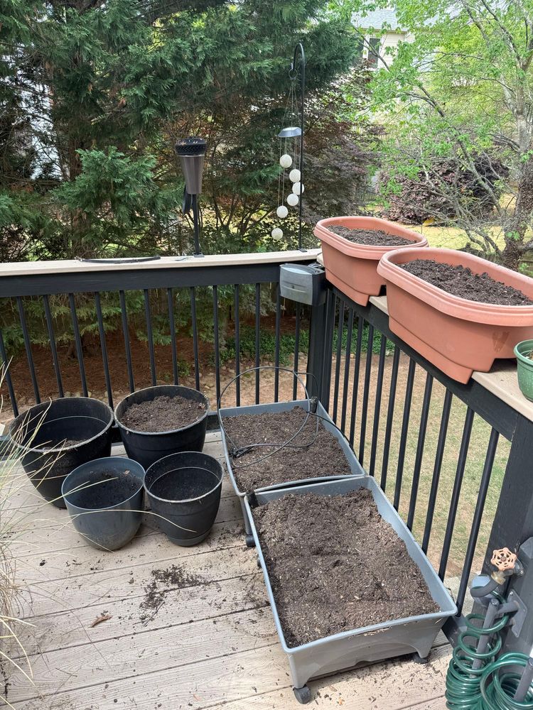 Pots on a porch filled with soil. 