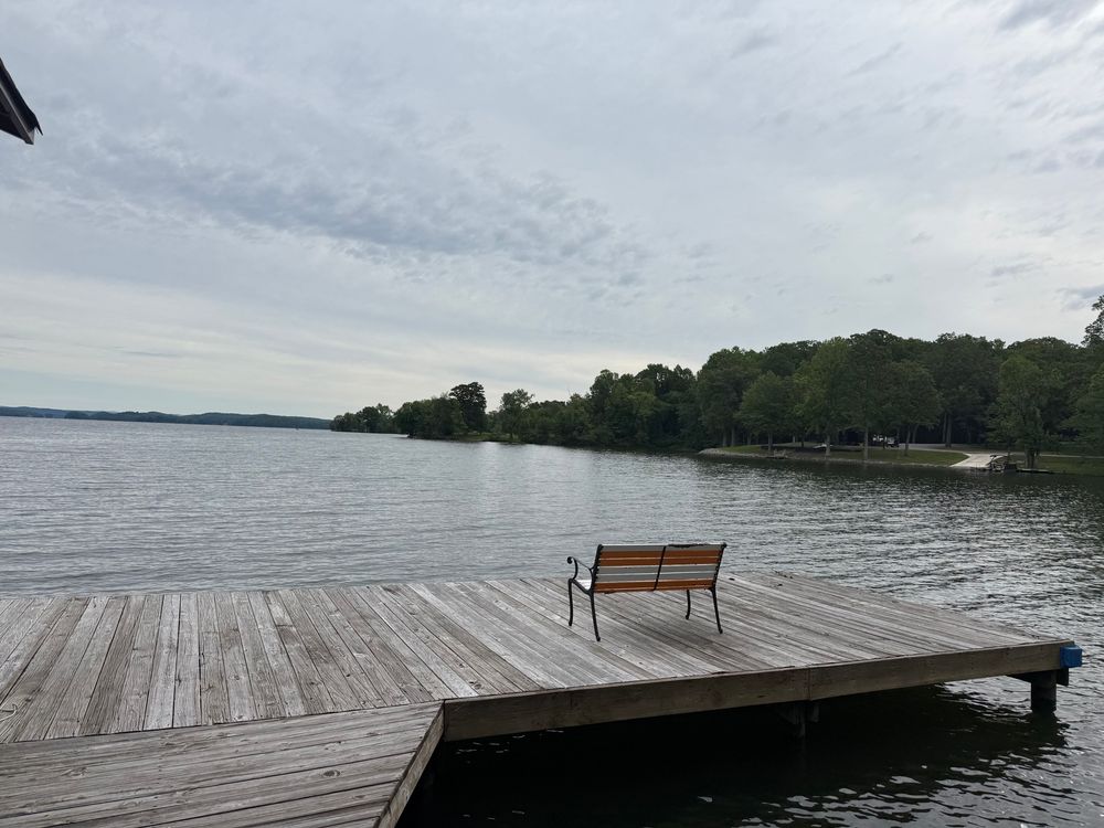 Photo of dock and lake with cloud cover and sunrise views. 