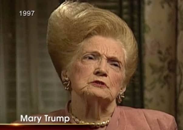 A picture of Mary Trump, Donald Trump's mother, staring at the camera with a pinched expression. She is wearing a pink top and a strand of pearls. Her hair is styled into an enormous dyed-blonde bouffant that almost appears to have a point on top, like the 1950s Sprite mascot's.