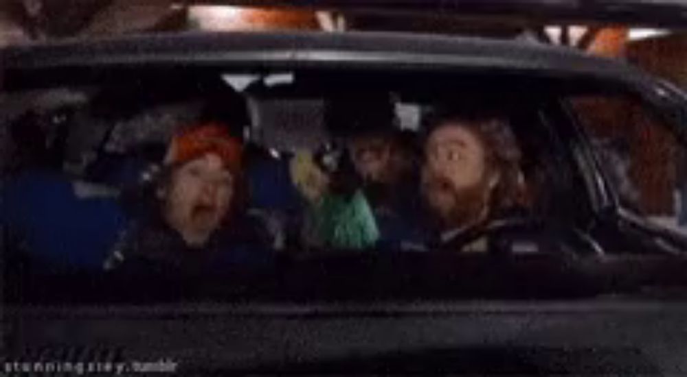 a group of men are sitting in a car .