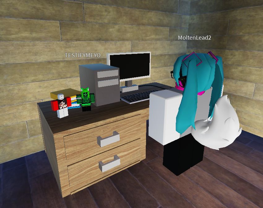 scene in roblox studio. my avatar in front of a computer and two of my friends on the desk like action figures