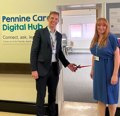 Anthony and Monique cutting a ribbon in the doorway of Pennine Care Digital Hub