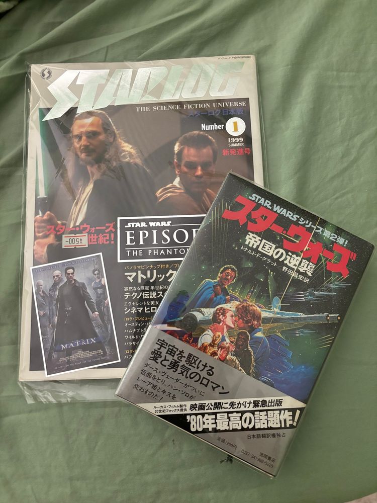 A Japanese edition of Starlog magazine from summer 1999 featuring The Phantom Menace as the cover story, and the 1997 Japanese edition of the Empire Strikes Back novelization 