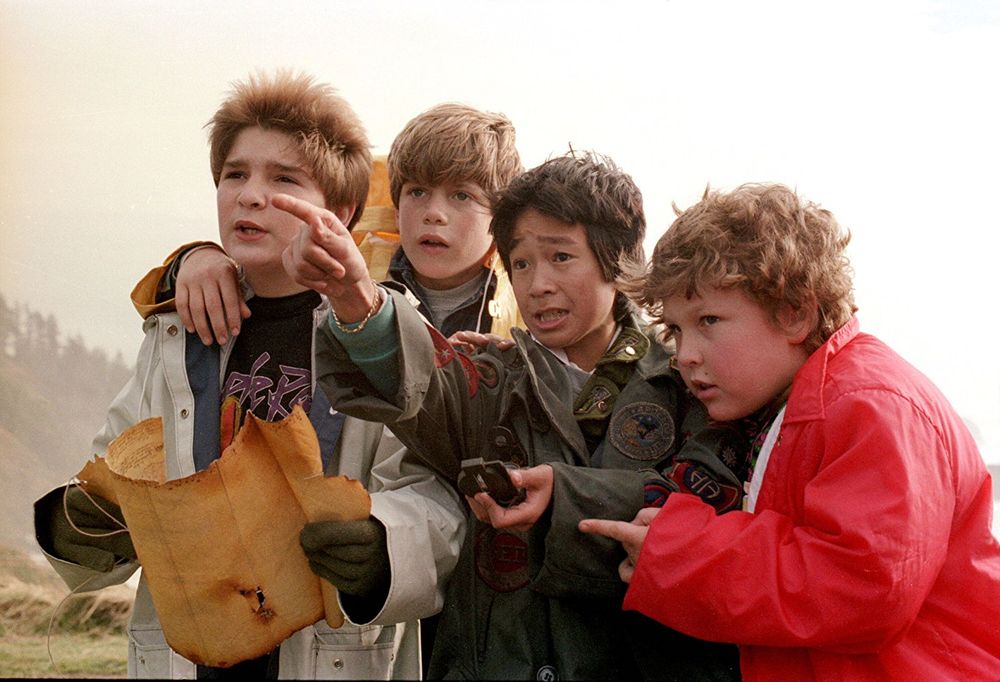 The kids from The Goonies looking at a map. One of them is pointing into the distance. There are four of them, because each of them has three friends.