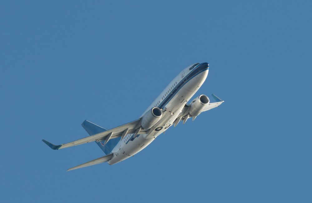 A twin-engined jet banking against clear blue sky