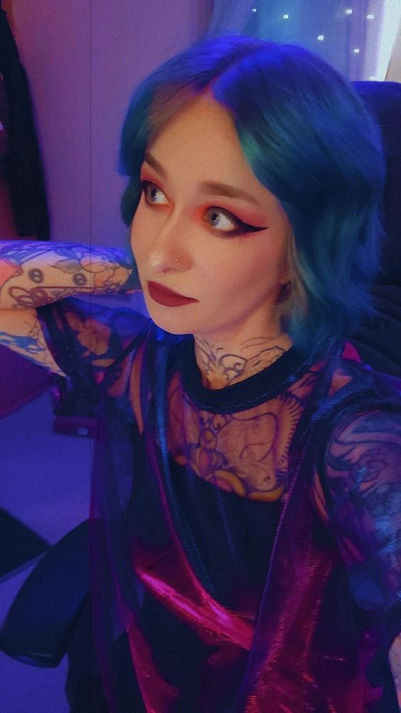 boba has blue hair and a shiny red holographic style shirt! 