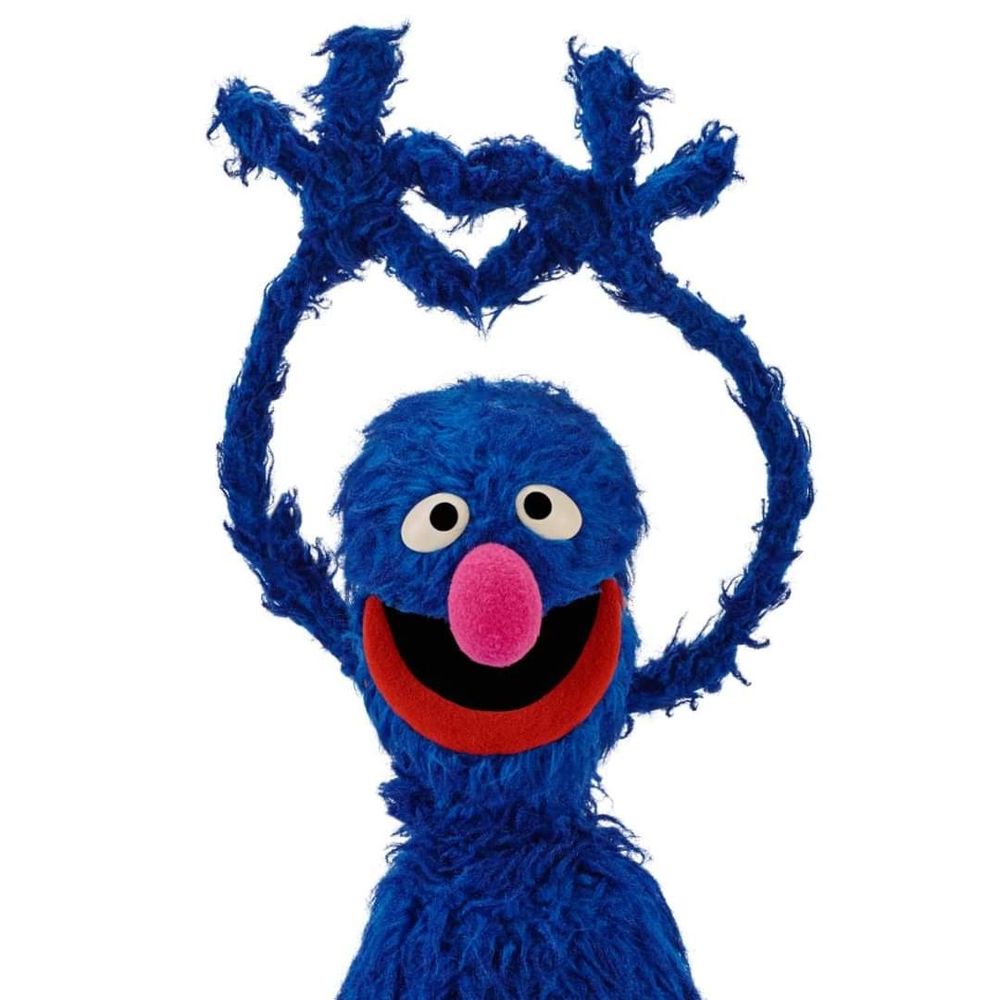 Grover the sesame street muppet making a heart shape with his fingers