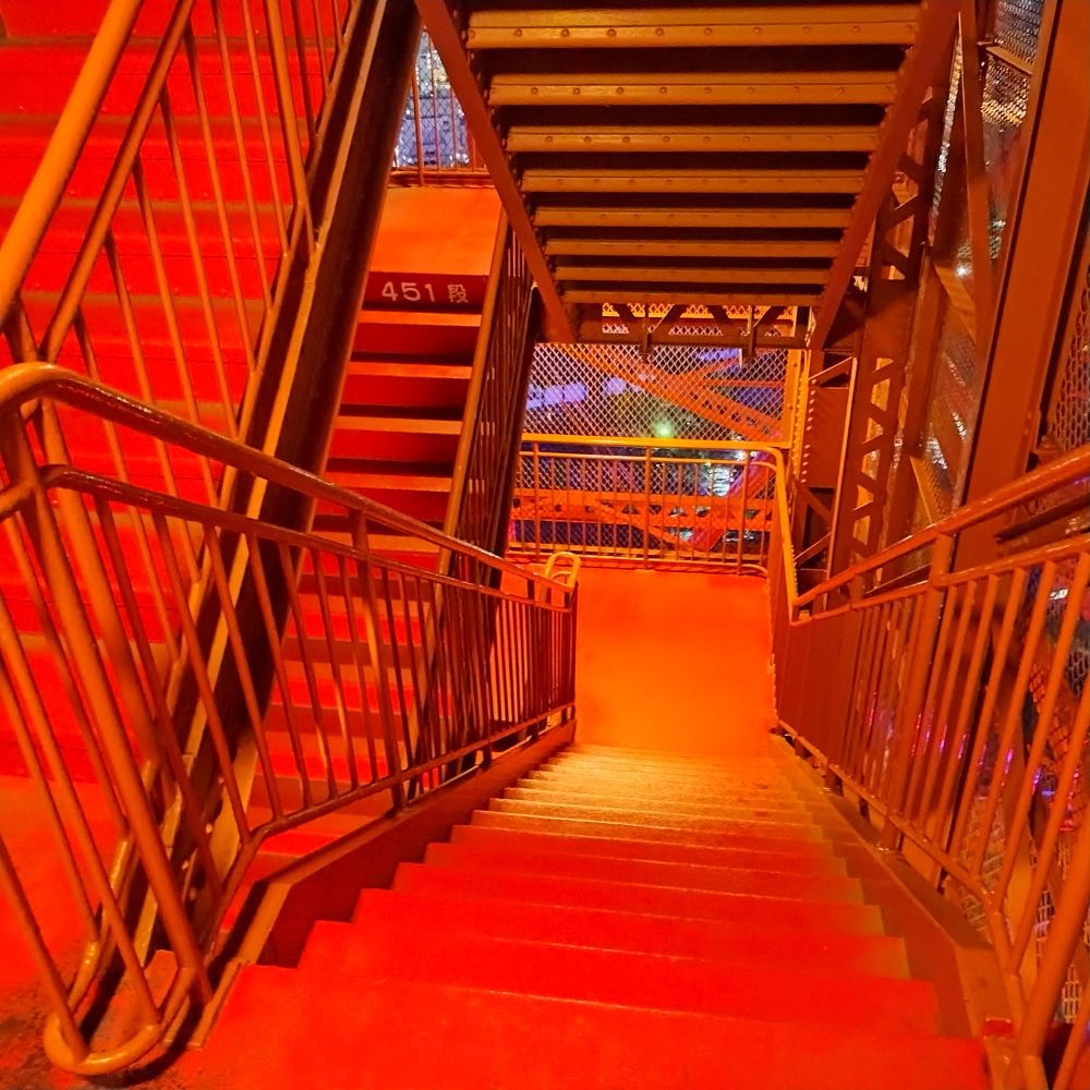Les escaliers de la tour de Tokyo lors de la descente de l'étage à 350m baignés d'une lumière rouge 