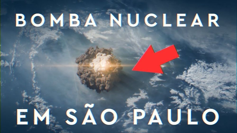 imagem aérea com um monte de fumaça em um ponto, com um clarão no meio. nas partes de cima e baixo tem um texto: "BOMBA NUCLEAR EM SÃO PAULO". tem uma seta vermelha apontando pra fumaça da explosão