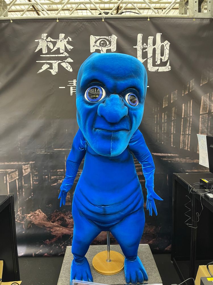 it’s the Ao Oni from the Ao Oni video games (not a person in a suit, but a large model)