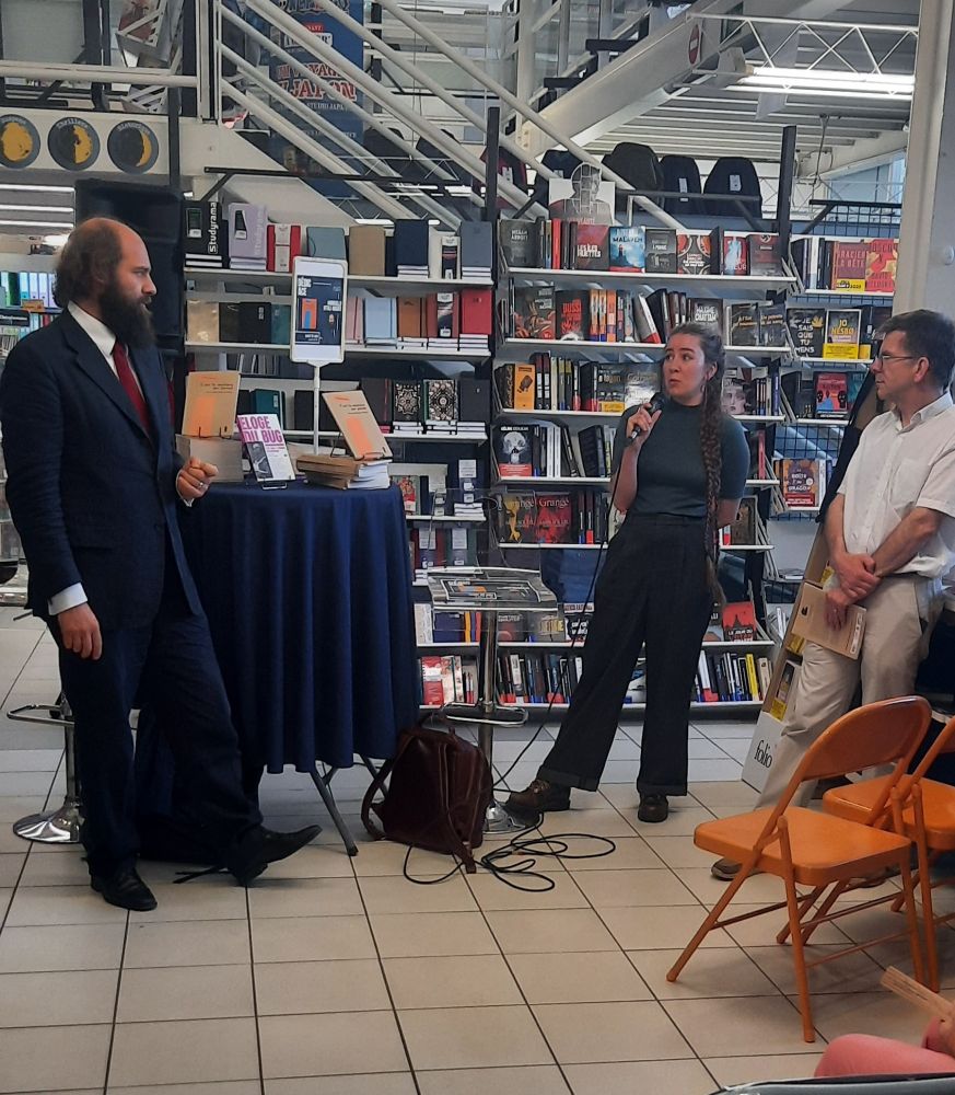Photographie de Marcello Vitali-Rosati, auteur de "C'est la matière qui pense", Margot Mellet, directrice de la collection "De code et de plomb" et Tony Gheeraert, directeur de PURH. On voit en fond les rayonnages de la librairie. 