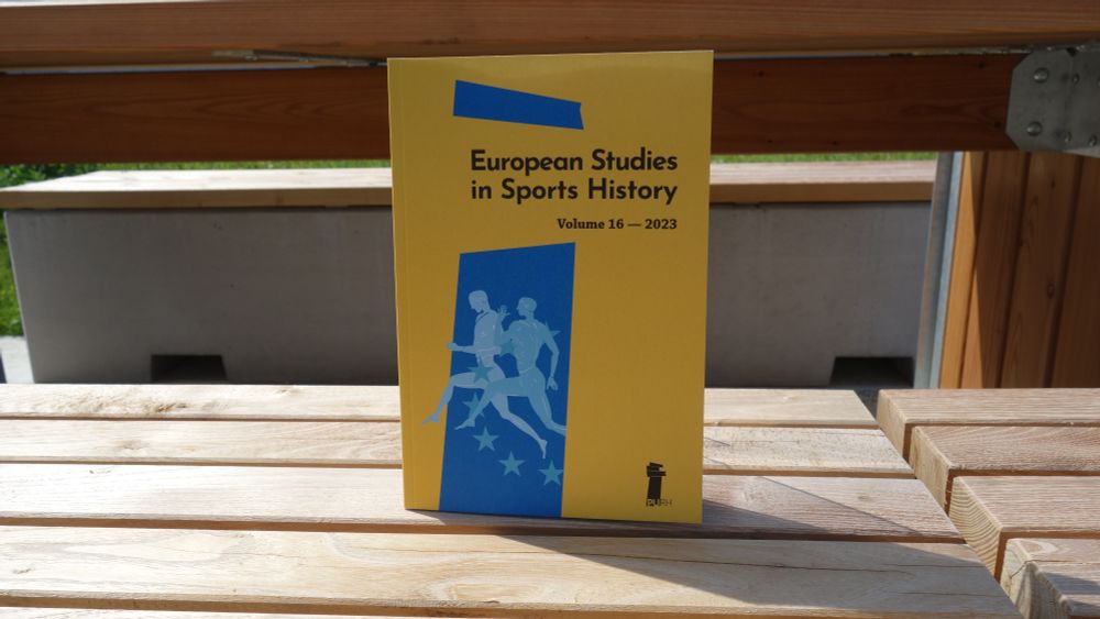 Photographie du numéro 16 de la revue European Studies in Sports History, dont la couverture est jaune, avec une bande bleue. L'ouvrage est posé debout, en extérieur et au soleil, sur un banc en bois, et on distingue un autre banc derrière lui.