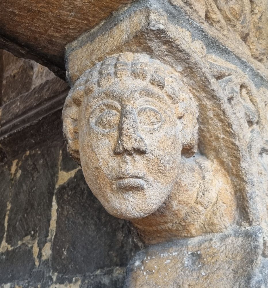 A twelfth-century carved head from the 'Prior's Door' of Ely Cathedral, with large almond eyes and a rather nervous expression.