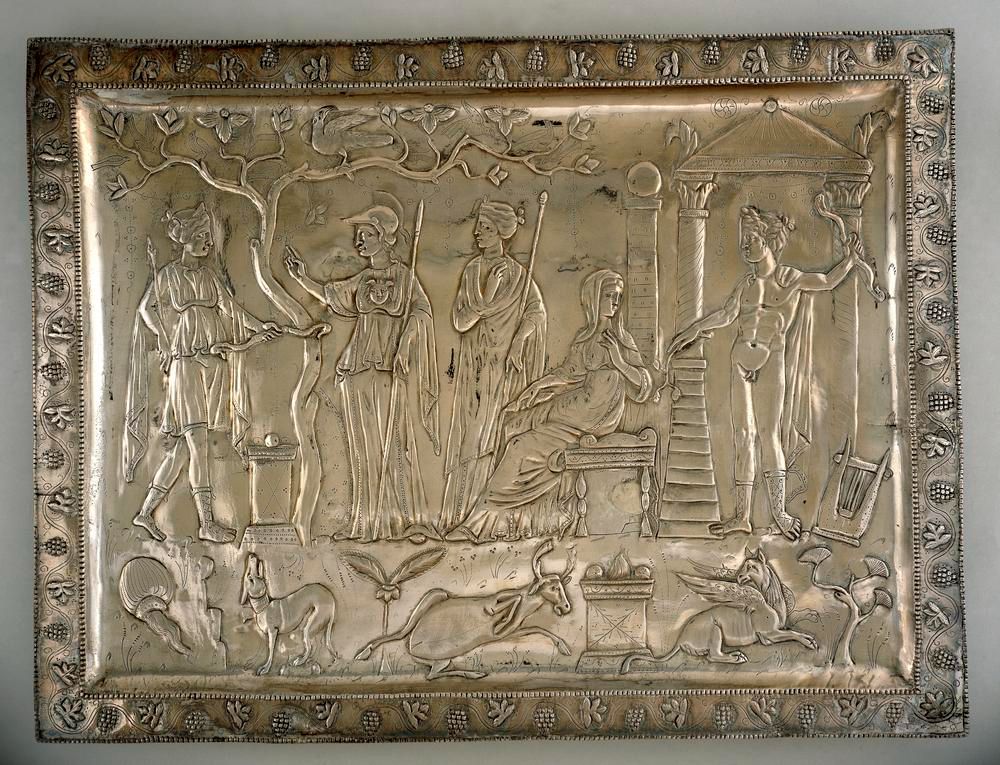 A Roman silver tray featuring images of Roman gods gathered around a shrine. Animals also appear, and the tray has a decorative vine around its rim.