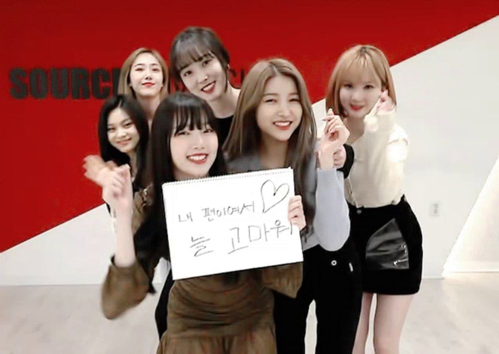 a group of girls are posing for a picture with a sign that says source