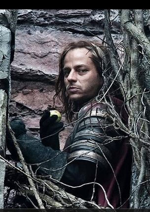 Image of Tom Wlaschiha as Jaqen H'ghar from Game of Thrones eating an apple whilst looking through tree branches.